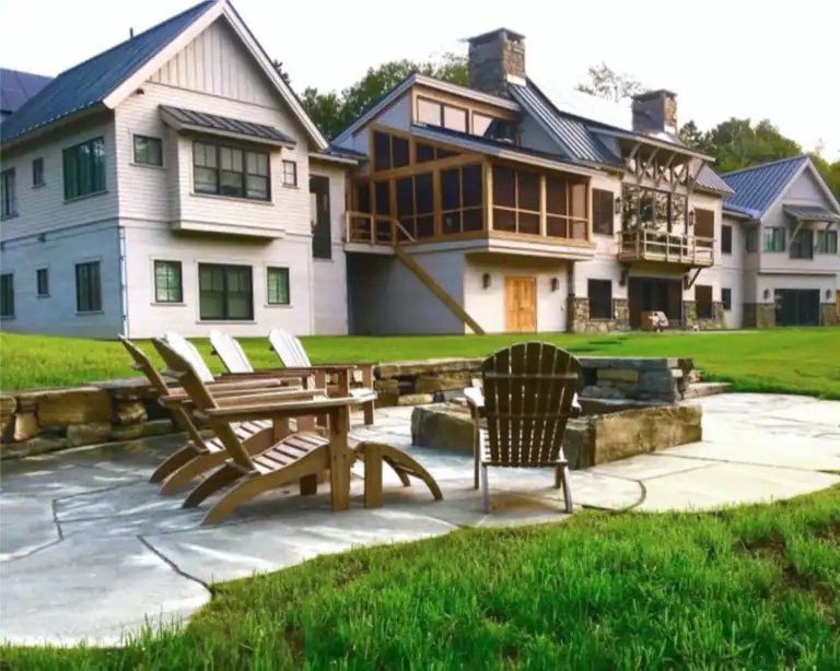 Photo of a large coastal house with stone work and an outdoor patio